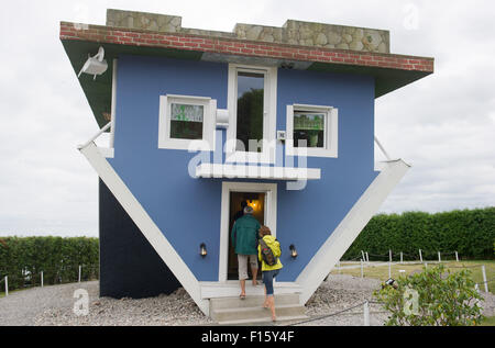 Wolgast, Allemagne. Août 25, 2015. Deux visiteurs entrent dans une maison qui est à l'envers à Wolgast, Allemagne, 25 août 2015. Deux hommes d'affaires de Stettin en Pologne construit la maison sur l'île Usedom en 2008. Le projet 'Die Welt steht Kopf" (lit. 'Le monde est à l'envers') est devenu un aimant pour les visiteurs et attire jusqu'à 50 000 visiteurs par an. Photo : STEFAN SAUER/dpa/Alamy Live News Banque D'Images