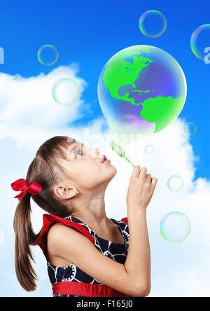 Image conceptuelle, enfant girl blowing soap bubble formant terre globe Banque D'Images