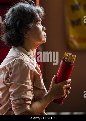 Bangkok, Bangkok, Thaïlande. Août 28, 2015. Une femme prie dans le POH Teck Tung de culte dans le quartier chinois de Bangkok sur l'esprit affamé 24. Les Bouddhistes Mahayana croient que les portes de l'enfer sont ouvertes sur la pleine lune du septième mois lunaire du calendrier chinois, et les esprits des fantômes affamés admis pour parcourir la terre. Ces fantômes ont besoin de nourriture et de mérite à trouver leur chemin de retour à leur propre. Les gens à s'aider en offrant de la nourriture, l'argent en papier, des bougies et des fleurs, ce qui en mérite de leur propre dans le processus. Esprit affamé jour est observé dans les communautés avec une grande population d'origine chinoise comme Bangkok's Chi Banque D'Images