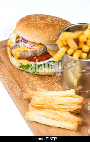 Hamburger et des frites dans la benne servant sur planche de bois Banque D'Images