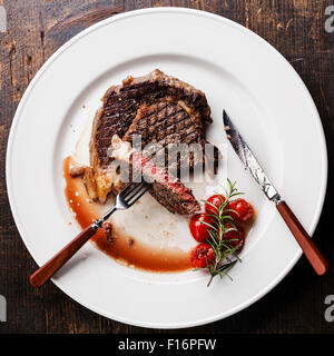 Tranches de steak de boeuf grillée saignante Ribeye avec tomates cerises grillées on white plate Banque D'Images