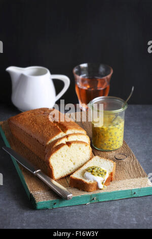 Pound cake avec de la crème et des fruits de la passion sur planche de bois Banque D'Images