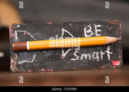 Être intelligent. Inscription en craie et crayon - fusée. L'étiquette avec l'inscription sur le bureau. Banque D'Images