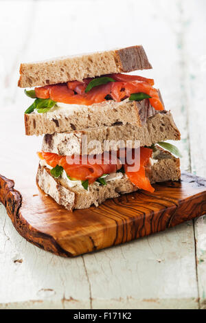 Sandwich avec saumon fumé, poisson rouge bleu sur fond de bois Banque D'Images