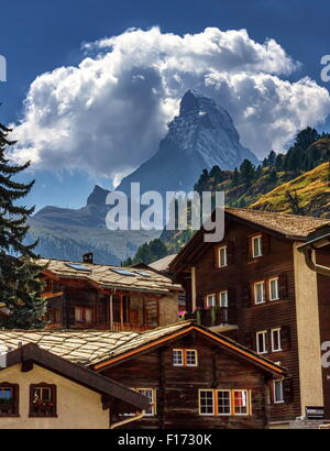 Matterhorn entourée de nuages en face de maisons de village de Zermatt par jour, Zermatt, Suisse Banque D'Images