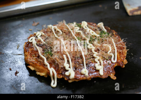 Okonomiyaki crêpe salé japonaise sur plaque chauffante Banque D'Images