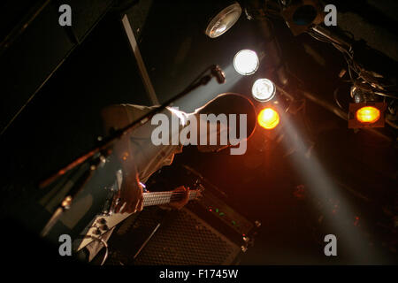 Le guitariste basse jouant ci-dessous stage lights Banque D'Images