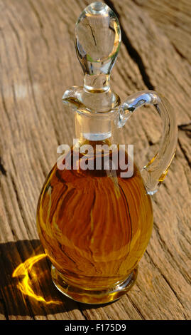 Carafe en verre avec de l'huile d'olive sur la table en bois rustique Banque D'Images