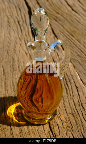 Carafe en verre avec de l'huile d'olive sur la table en bois rustique Banque D'Images