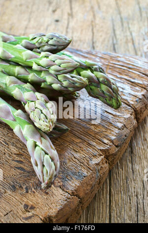 Vue rapprochée de l'asperge verte fraîche sur une planche à découper en bois rustique Banque D'Images