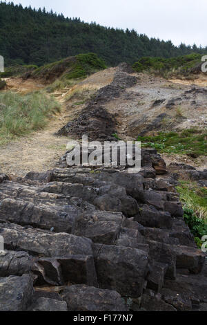 La caractéristique naturelle de la côte de l'Oregon central où la pierre de lave solidifiée et fissures remplis séparant la terre Banque D'Images