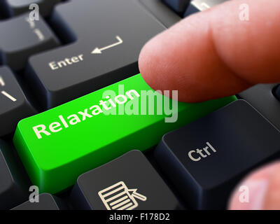 Relaxation - written on Green touche du clavier. Homme de main appuie sur le bouton noir sur le clavier du PC. Vue rapprochée. Arrière-plan flou. Banque D'Images