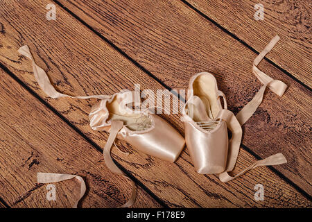 Pointes de ballet s'allonger sur le sol en bois. Vintage. Le concept de ballet classique et la danse moderne. Shot close-up. Banque D'Images