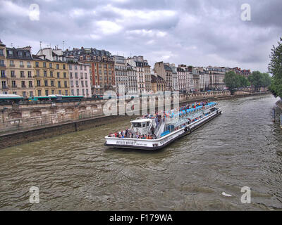 Paris, France, Europe - 21 juin 2013 : Bateau de tourisme (Bateaux-Mouches) avec passagers à bord croisière le long de la Seine. Banque D'Images