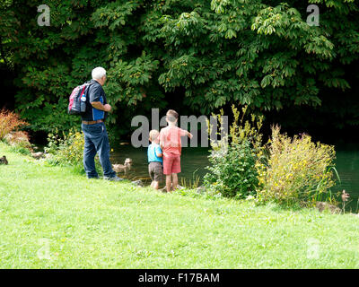 Deux jeunes garçons avec leur grand-père à regarder les canards, Marlborough, Wiltshire, Royaume-Uni Banque D'Images