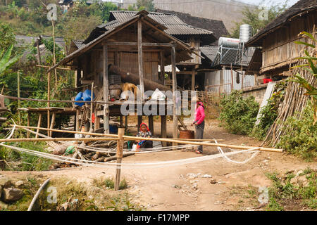 Village rural dans le Xishuangbanna, Yunnan, Chine, où les femmes sont le tissage et filage à la mode traditionnelle Banque D'Images