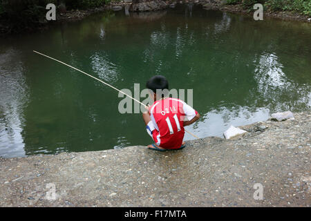 Petit garçon de pêche dans la région de Arsenal shirt avec ventilateur Ozil Banque D'Images