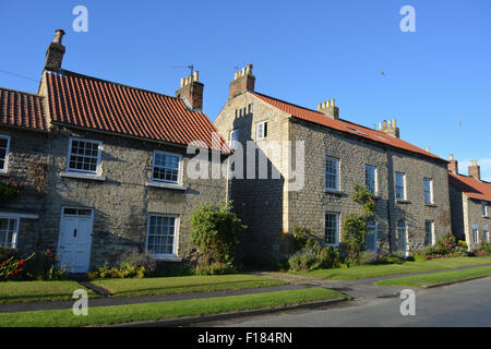 Scène de rue résidentielle et semi-détachée détachée cottages en Hovingham, North Yorkshire, Angleterre Banque D'Images