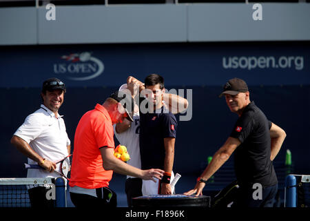 New York, USA. Août 29, 2015. Numéro un Novak Djokovic gagne un peu d'aide s'étend pendant une séance d'essai à l'USTA Billie Jean King National Tennis Center de Flushing Meadows, New York le Samedi, Août 29th, 2015. Il se prépare à l'US Open qui débute lundi. Dans l'avant-plan dans la chemise orange est coach, Boris Becker. Crédit : Adam Stoltman/Alamy Live News Banque D'Images