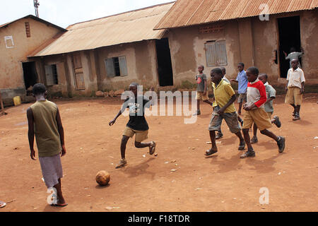 Les enfants prennent le temps de jouer au soccer dans un bidonville de la capitale ougandaise, Kampala Banque D'Images