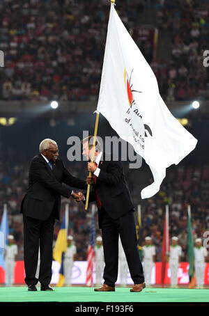 Beijing, Chine. Août 30, 2015. Le président de l'IAAF Lamine Diack (L) les mains sur le drapeau de l'IAAF à UK Athletics (UKA) président Lynn Davies lors de la cérémonie de clôture des Championnats du monde IAAF 2015 au 'nid d'oiseau' Stade national de Beijing, capitale de la Chine, 30 août 2015. © Li Gang/Xinhua/Alamy Live News Banque D'Images