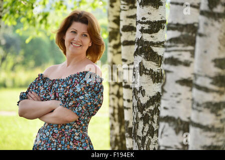 Femme dans une robe à épaules est ouverte à propos de Birch Banque D'Images