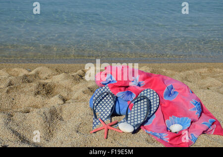 Foulard paréo en été et des tongs avec la mer bleue en arrière-plan Banque D'Images