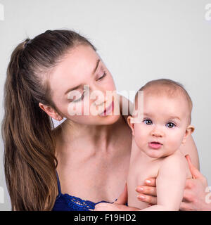 Mignon bébé et mère portrait sur fond blanc Banque D'Images