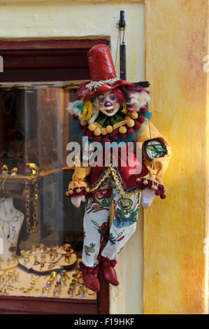 Une marionnette clown colorée suspendu à chaînes en dehors d'une vitrine à Santorin, Grèce. Banque D'Images