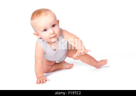 Studio shot of baby boy jouant sur le sol à la recherche de l'appareil photo. Banque D'Images