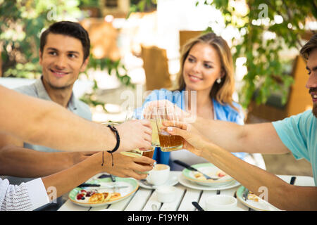 Happy friends making toast autour de table à dîner dans le restaurant de plein air Banque D'Images