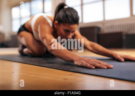 Woman doing stretching entraînement sur tapis de fitness, se concentrer sur les mains, fitness yoga féminin sur tapis d'exercice à la salle de sport. Banque D'Images