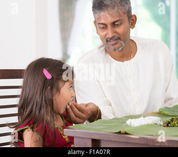 Repas à la maison de la famille indienne. Photo de Candide inde personnes manger du riz avec les mains. Alimentation parent enfant. Banque D'Images