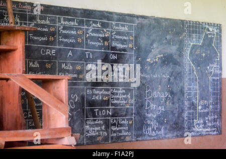 Tableau noir d'une salle de classe en milieu rural Bénin montrant le calendrier et une carte du Bénin Banque D'Images