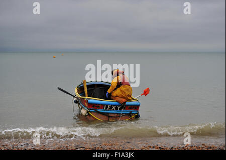 Brighton UK Lundi 31 août 2015 - Un pêcheur têtes hors de la plage de Brighton Bank Holiday Août tôt ce lundi matin dans l'espoir d'attraper une pause dans le temps humide avec des prévisions pour le sud-est étant pour de fortes pluies et d'orages possible Crédit : Simon Dack/Alamy Live News Banque D'Images