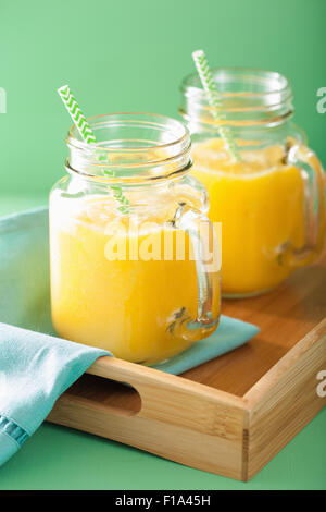 Smoothie mangue jaune sain avec ananas banane dans des bocaux Mason Banque D'Images