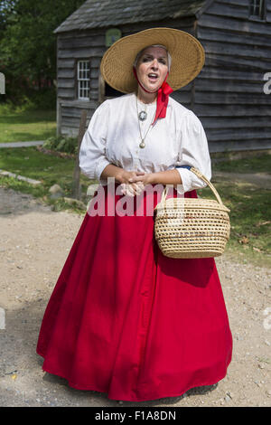 Old Bethpage, New York, USA. Août 30, 2015. JANET DEMAREST est le conteur de légendes locales Long Island au cours de l'Old Time Music Week-end à Old Bethpage Village Restauration. Demarest portait un panier en paille et portait un grand chapeau de paille bord, un chemisier avec dentelle et longue jupe cercle rouge dans le style du milieu du 19ème siècle. Credit : Ann Parry/ZUMA/Alamy Fil Live News Banque D'Images