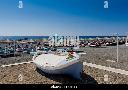 Les touristes à bronzer sur la plage noire de Kamari, Santorini, Grèce. Banque D'Images