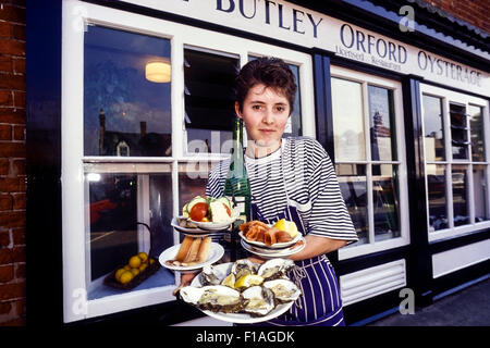 Une serveuse avec une sélection d'huîtres fraîches et le poisson fumé à l'Orford Butley Oysterage. Le Suffolk. L'Angleterre. UK Banque D'Images