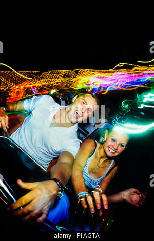 Un jeune couple appréciant un roller coaster ride de nuit à l'île de l'aventure. Southend-on-Sea. L'Essex. UK Banque D'Images