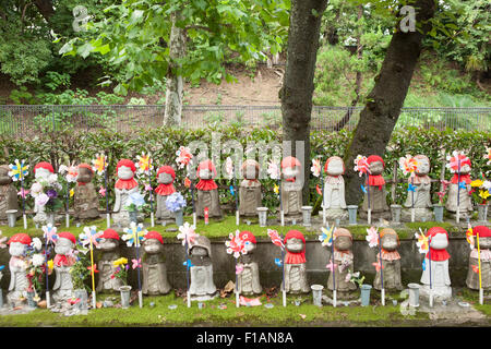 Japon, Tokyo, rangées de statues Jizo décorées avec des bavoirs, des caps, des fleurs et des roulades au Temple Zojoji Banque D'Images