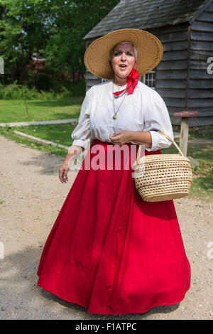 Old Bethpage, New York, USA. 30 août, 2015. JANET DEMAREST est le conteur de légendes locales Long Island au cours de l'Old Time Music Week-end à Old Bethpage Village Restauration. Demarest portait un panier en paille et portait un grand chapeau de paille bord, un chemisier avec dentelle et longue jupe cercle rouge dans le style du milieu du 19ème siècle. Credit : Ann E Parry/Alamy Live News Banque D'Images