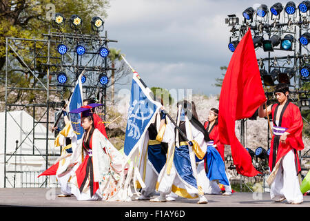 Festival de danse japonaise de Yosakoi. Sur scène la troupe de danse à l'extérieur en affaires courantes basées sur l'histoire. Danseurs holding drapeau comme la princesse s'agenouille. Banque D'Images