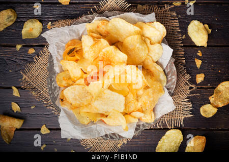 Bol de croustilles de pommes de terre sur une table rustique. Photographié à partir de juste au-dessus. Banque D'Images