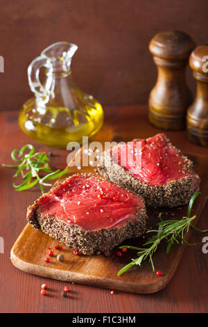 Steak de boeuf aux épices et de romarin sur fond de bois Banque D'Images