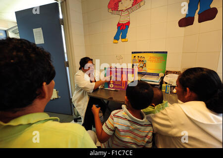 Guatemala, Guatemala City, médecin (Maria Eugenia Luarte) recevant le SIDA/VIH femme patient et de donner des conseils sur les risques et les comportements (Carlos Cabrera 43 Zoila, Cristina Cruz 43, David Andres Cabrera Cruz 5, Ange Gabriel Cabrera Cruz 11 mois) Banque D'Images