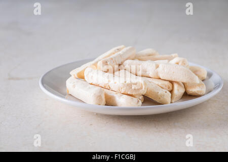 Gros plan gâteau crème dessert délice cookies décoration détail nourriture tas de meringue pièce écrou la forme de la plaque de table doux vanille Banque D'Images