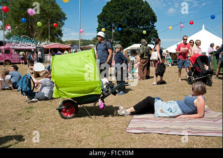 Les familles se réunissent autour de stands de nourriture et de tentes de l'événement dans le soleil d'été au Port Eliot Cornwall Festival Banque D'Images