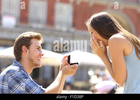 Proposition dans la rue avec un homme demandant à se marier à sa petite amie heureuse Banque D'Images