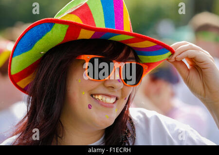 Femme à un organisme de bienfaisance color run, portant un chapeau stetson multicolores et lunettes de soleil en plastique, Sarajevo, Ecosse Banque D'Images